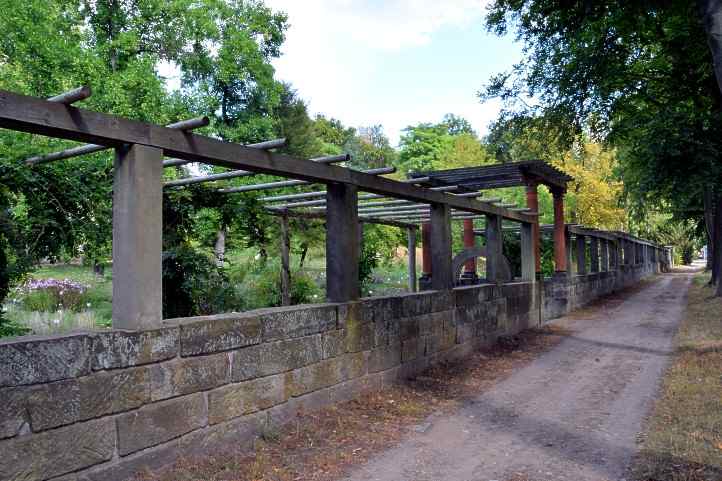 Eingang - Sandsteinmauer mit Pergola am Paradiesgarten.